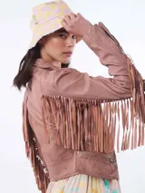 Chaqueta de cuero color rosa con flecos en mangas y espalda, cierre frontal asimétrico y bolsillos con cierre.