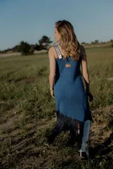 Vestido corto tejido en lurex con diseño geométrico en cuero en el frente, breteles de cuero intervenido a mano con tientos de cuero plateado y terminación en flecos.