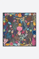 Pañuelo cuadrado con estampado de motivos marinos: corales, estrellas de mar, peces y conchas en colores vibrantes sobre fondo gris.