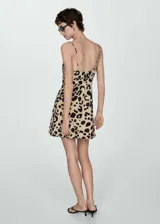 Vestido corto con tirantes finos y estampado animal print en tonos beige y negro.