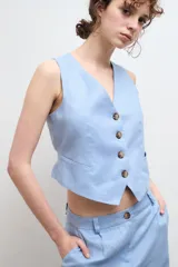 Chaleco sastre color amarillo mostaza, confeccionado en lino con forro de algodón y cierre frontal con botones.