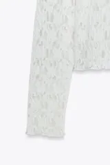 Camiseta negra de encaje con cuello alto y mangas largas.