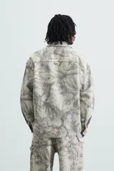 Sobrecamisa relaxed fit de algodón con cuello solapa, manga larga con puños abotonados, bolsillos de plastrón en el pecho, efecto lavado y cierre frontal abotonado. Estampado abstracto en tonos grises.