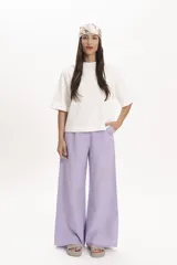 Pantalón de corte palazzo color lila, con cintura alta y bolsillos laterales.