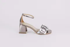 Sandalias plateadas de cuero con tiras entretejidas en el empeine, pulsera al tobillo con hebilla y tacón cuadrado. Marca Fiore.