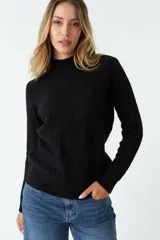 Sweater tejido color rosa con cuello alto y diseño de trenzas en el frente.