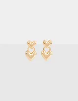 Aros colgantes cortos dorados con dos dijes en forma de corazón.