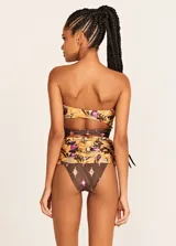 Conjunto de bikini Triya con estampado floral en tonos marrones, naranjas y violetas. El corpiño es strapless con nudo central y la bombacha es de tiro alto con aberturas laterales.