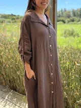 Vestido camisero amplio y largo de lino color azul, con botones de nácar, cuello camisero y bolsillos laterales.