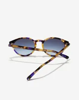 Gafas de sol Hawkers unisex, modelo Salt, con montura redonda de carey con detalles en lila y lentes degradadas en azul.