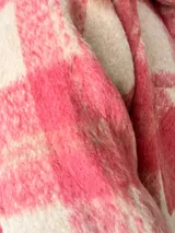 Campera oversize de paño con diseño cuadrillé en tonos rosa y crudo, corte recto y amplio, con botones frontales, bolsillos laterales y forro interior.