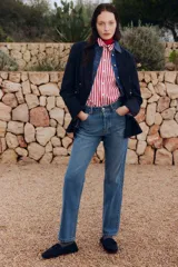 Pantalón de jean azul de corte recto, con tiro alto, cinco bolsillos y cierre con botones.