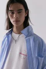 Remera blanca de corte holgado con estampado del logo de la banda Red Hot Chili Peppers en el pecho.
