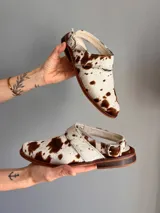 Suecos con capellada de cuero con estampado de vaca, con tira sobre el empeine y suela de madera.