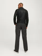 Chaqueta biker negra de cuero sintético con cierre de cremallera, cuello mao con botón a presión, detalles acolchados en los hombros, bolsillos laterales con cremallera, puños con cremallera y forro de poliéster reciclado.