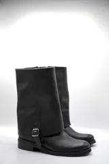 Bota de cuero negro con caña ancha y hebilla lateral.