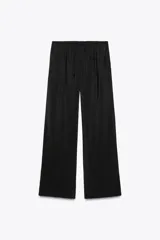 Pantalón negro de tejido fluido, tiro medio con cintura elástica ajustable con cordones, bolsillos laterales y falsos bolsillos de vivo en la espalda.