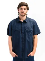 Camisa de manga corta color beige con cuello clásico, cierre frontal con botones, dos bolsillos con solapa abotonada en el pecho y corte recto. Ideal para actividades al aire libre.