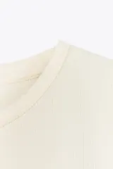 Vestido largo color crema, con cuello redondo y mangas cortas. Presenta corte a la altura de la cintura y falda amplia con terminación redondeada tipo globo.