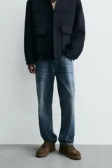 Pantalón de jean azul de corte recto, con cinco bolsillos, efecto lavado y cierre frontal con botones.