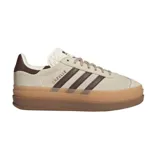 Zapatillas Adidas Gazelle Bold color beige con las tres tiras laterales en marrón. Suela de plataforma color caramelo.