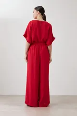 Pantalón palazzo rojo con pinzas, corte amplio y bolsillos laterales.