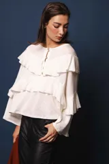 Blusa de lino color blanco, con silueta oversize, cuello bote y volados en el frente.