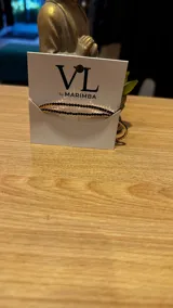 Pulsera elástica con cuentas facetadas negras y detalles dorados.