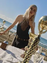 Top negro confeccionado en tweed de punto con detalle frontal en cuero marrón. Diseño con tiras que emergen desde el cuello, permitiendo ajustar el calce.