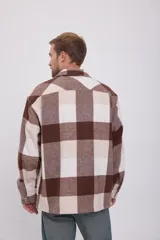Sobrecamisa Jack & Jones de manga larga con cierre de botones, bolsillos en el pecho y corte relajado. Diseño a cuadros grandes en tonos marrón y beige.