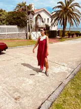 Vestido de fiesta fucsia con escote y espalda de cuero, tajos laterales con hilo metálico y terminación con flecos.