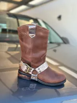 Bota de cuero marrón con estribo desmontable plateado.
