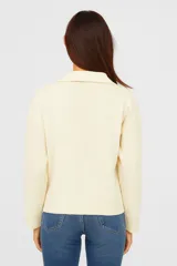 Sweater color crema de poliéster, corte relaxed y cuello en V.