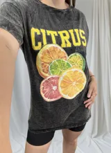 Remerón negro con efecto gastado y estampado de limones, naranjas y pomelos, con la palabra 'Citrus' en amarillo.