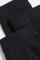 Pack de tres calzoncillos tipo trunk de color negro, confeccionados en tejido elástico con costuras planas, cintura elástica, piernas cortas y parte delantera forrada. Fabricados con tecnología Lycra® Xtra Life™.