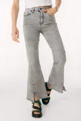 Pantalón de jean azul de corte acampanado con aberturas en el ruedo.