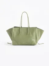 Bolso tote pequeño de cuero vacuno negro, con cierres funcionales en los laterales para mayor apertura y espacio. Incluye bolsillo cruzado interno y tag con aplique metálico.