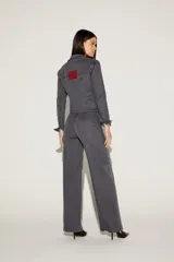 Pantalón de jean gris oscuro, corte wideleg, con apliques brillantes en la parte superior y en los bajos.