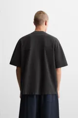 Camiseta negra de corte cuadrado, con cuello redondo, mangas cortas y efecto lavado.