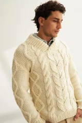 Sweater tejido a mano con ochos y cuello cruzado, color crema. Terminaciones en punto elástico en puños y ruedo. Hecho en Uruguay con lana fina sin teñir.