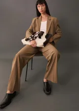 Pantalón de vestir color beige, de corte wide leg, con trabillas, tejido fluido, detalle de pinzas, dos bolsillos laterales y cierre oculto de botón, gancho y cremallera.