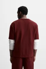 Camiseta negra de corte holgado, con cuello redondo y mangas cortas.