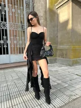 Vestido corto negro con breteles finos, escote recto y falda con volados asimétricos.