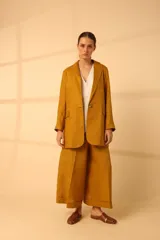 Blazer de lino color beige, de corte recto, con solapas y cierre de un botón.