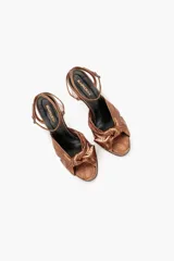 Sandalias negras de cuero metalizado con taco alto y tira fina al tobillo.