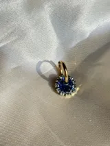 Arito dorado con forma circular, centro negro y strass blancos alrededor. Se vende por unidad.