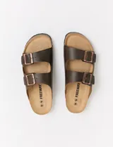 Sandalias Freeway de cuero marrón con doble tira y hebillas metálicas color cobre.