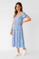 Vestido midi de viscosa con estampado de hojas en tonos beige y marrón, corte ancho, cuello en V y mangas cortas con volados.