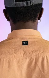 Camisa manga larga color mostaza de calce relaxed fit. Cuenta con detalles de canesú en frente y espalda, y aberturas en laterales. Su tela gamuzada le brinda a la prenda una textura de exclusiva suavidad.