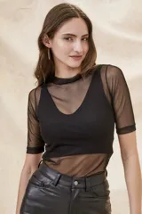 Polera negra de manga corta con cuello alto, confeccionada en tul transparente.